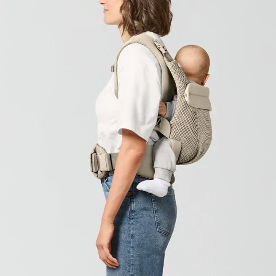 Parent carrying older baby in outward-facing position in the Cybex Amya Baby Carrier, side profile view