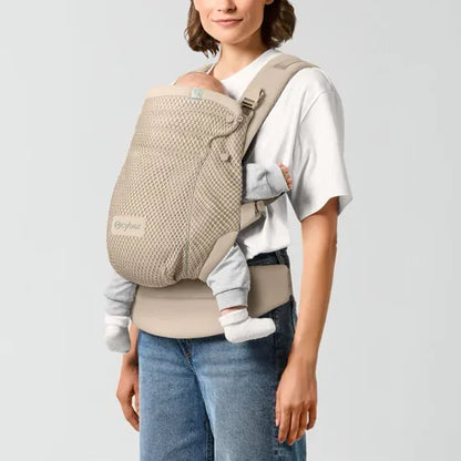 Parent carrying newborn facing inward in the Cybex Amya Baby Carrier in Natural Beige, front carry position