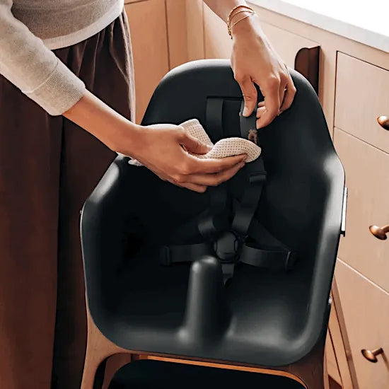 Parent wiping the silicone harness on the UPPAbaby Ciro V2 High Chair in Mason black