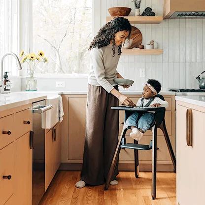UPPAbaby Ciro V2 High Chair in Mason black with a parent feeding her baby in a bright kitchen